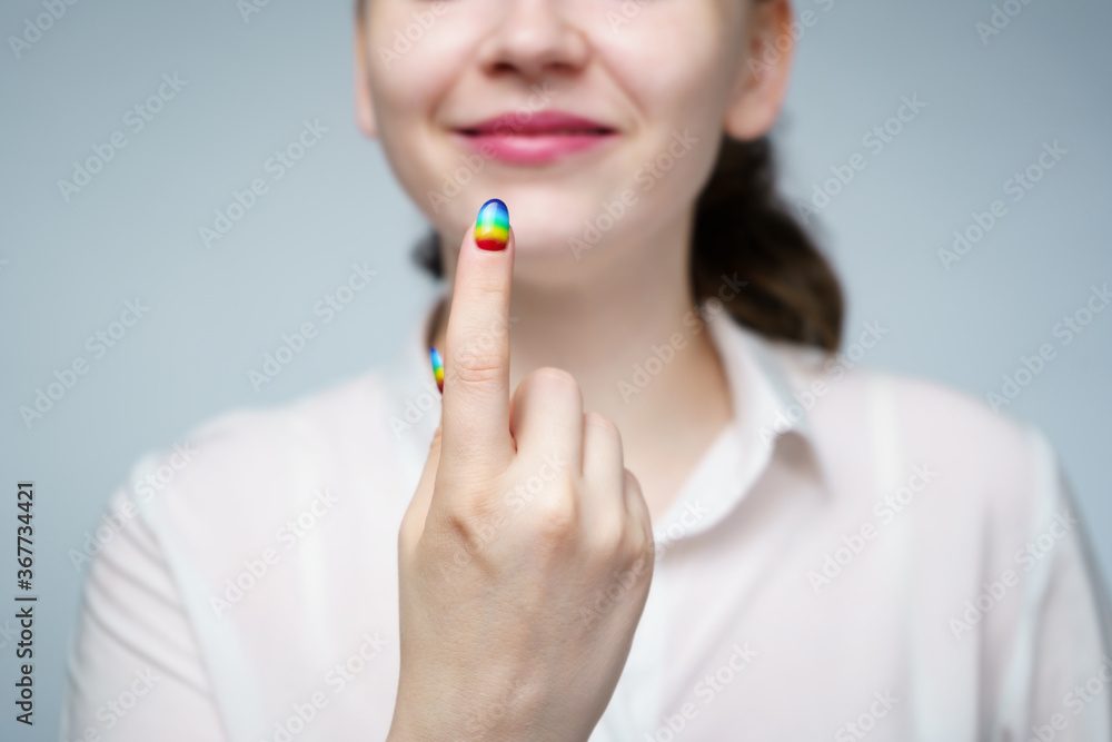 Photo of woman with rainbow manicure beckoning finger Photo of woman with rainbow manicure beckoning finger