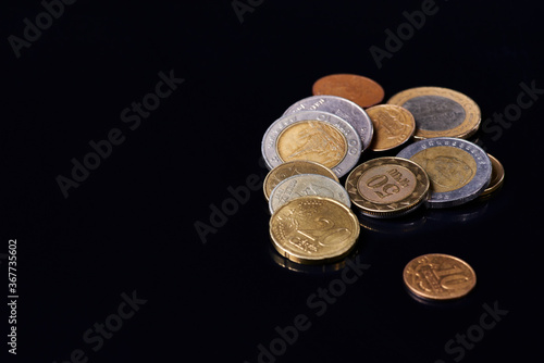 coins of different countries, on black glass