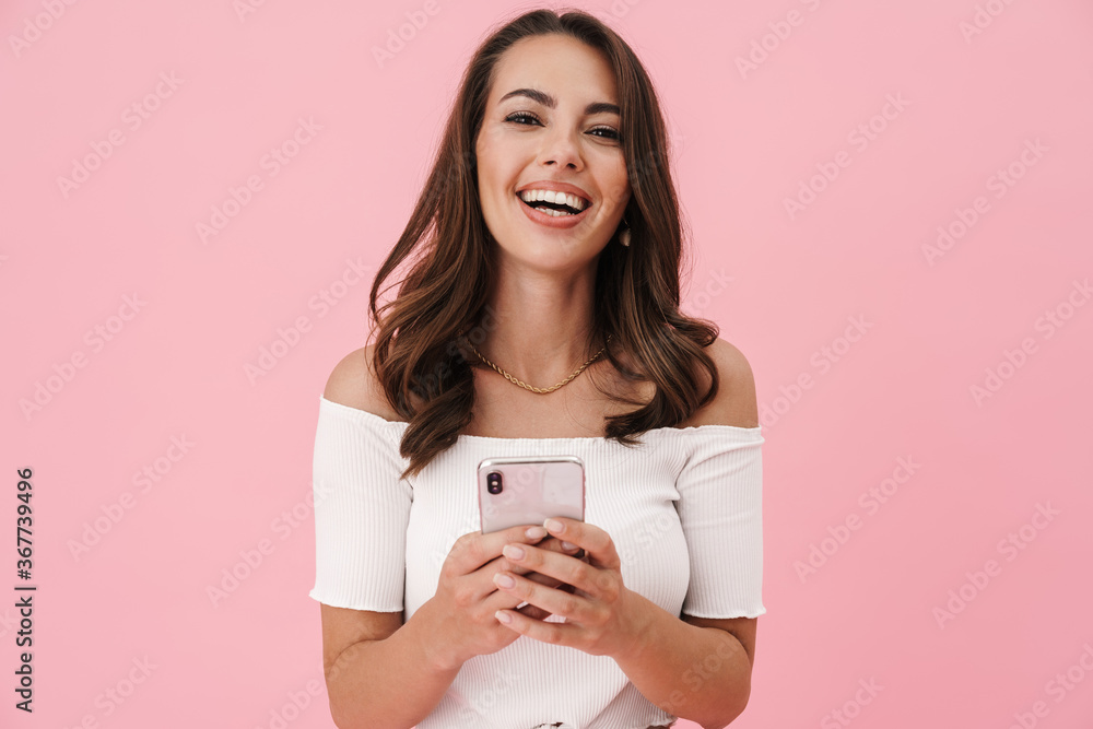 Image of joyful brunette woman using cellphone and laughing Image of joyful brunette woman using cellphone and laughing