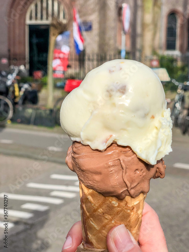 hand holding ice cream cone at street in Europe