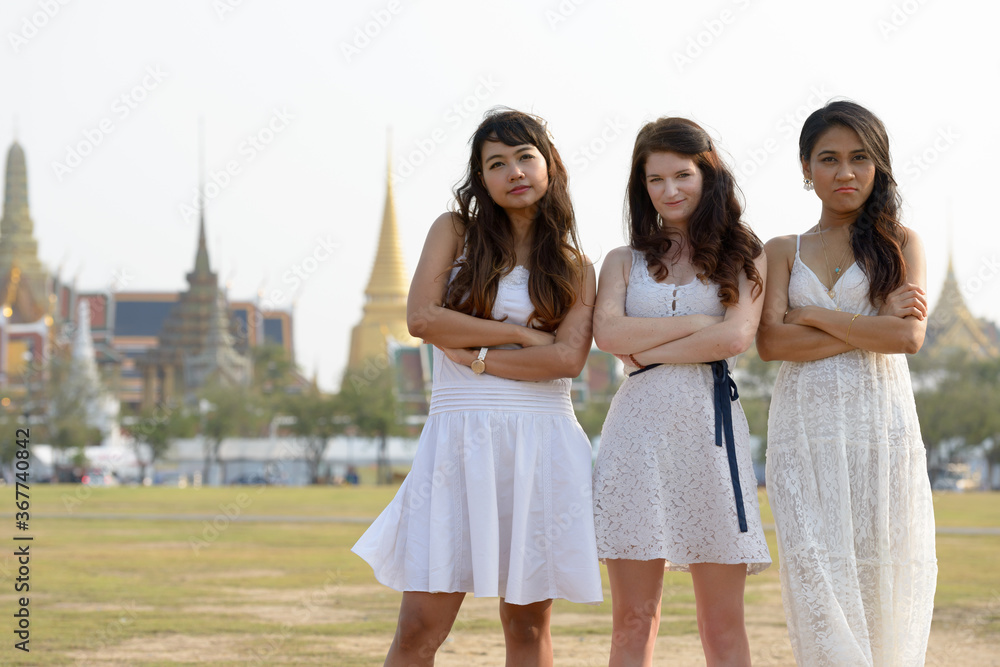 Three multi ethnic young beautiful women as friends together in the park Three multi ethnic young beautiful women as friends together in the park