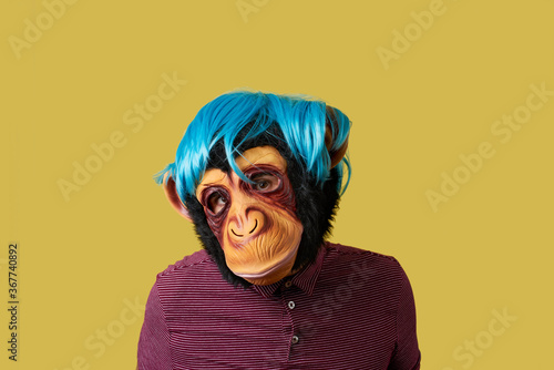 Photography man wearing a monkey mask and a wig