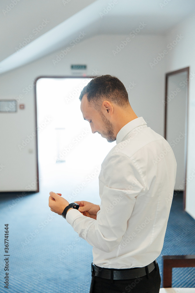 Portraits of the groom at the hotel training camp, dressed as a businessman in a black suit, tuxedo and white shirt Portraits of the groom at the hotel training camp, dressed as a businessman in a black suit, tuxedo and white shirt
