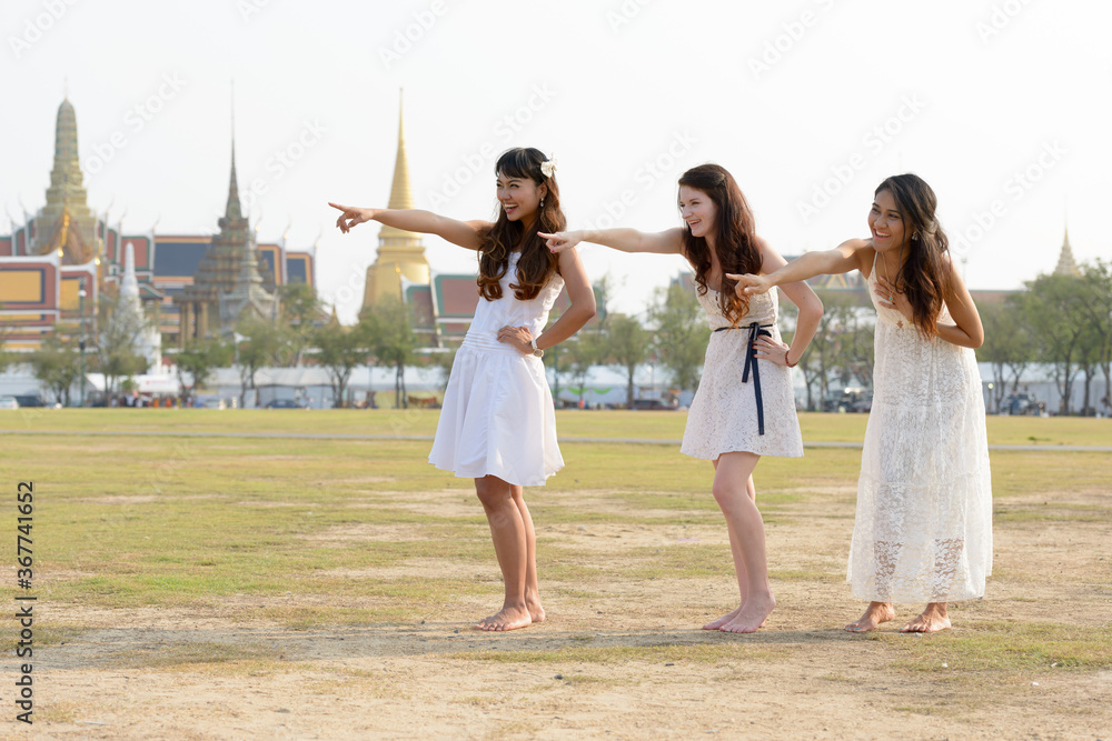 Obraz premium Three multi ethnic young beautiful women as friends together in the park