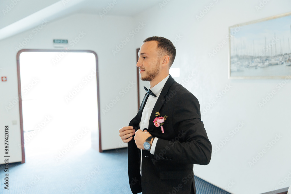 Portraits of the groom at the hotel training camp, dressed as a businessman in a black suit, tuxedo and white shirt Portraits of the groom at the hotel training camp, dressed as a businessman in a black suit, tuxedo and white shirt