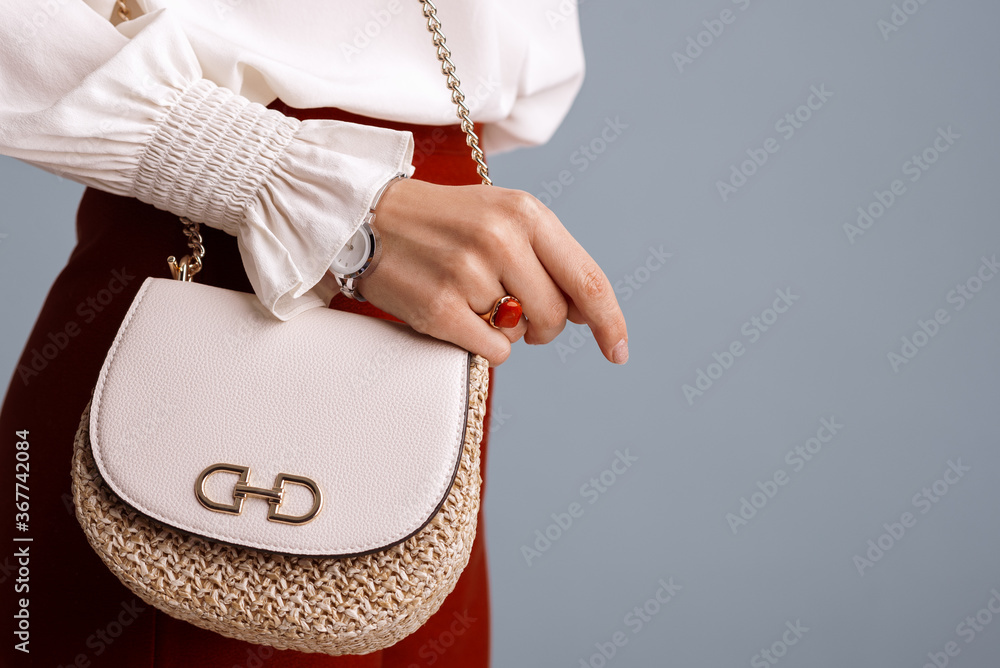 Close up of fashionable elegant woman`s outfit: trendy small shoulder bag,  stylish wrist watch, beautiful ring with red gem. Copy, empty space for  text Stock Photo
