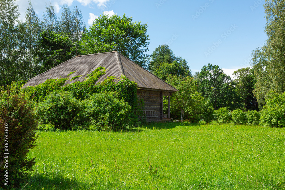 Old wooden house on the green well-tended lawn. Horizontal image. Old wooden house on the green well-tended lawn. Horizontal image.
