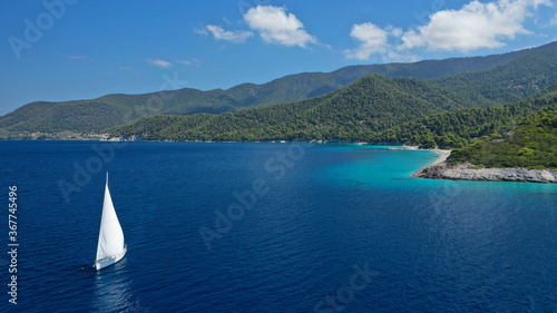 Aerial drone photo of beautiful sail boat with white sails, sailing open ocean deep blue Mediterranean sea
