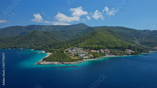 Aerial bird's eye view photo taken by drone of tropical seascape and sandy beach with turquoise clear sea and pine tree forest