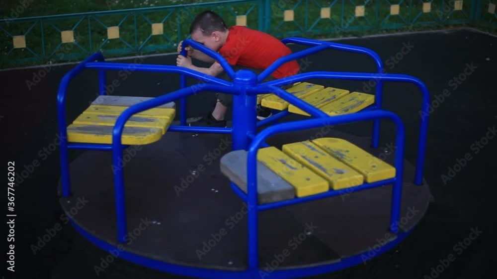 The child is spinning on a carousel. Boy on the playground. The child is bored alone on the carousel. The younger student is testing the playground. A boring day for a child. Rest of the child without The child is spinning on a carousel. Boy on the playground. The child is bored alone on the carousel. The younger student is testing the playground. A boring day for a child. Rest of the child without