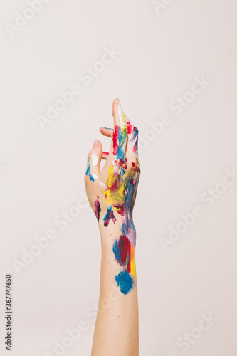 Close up woman's artist's hand in paints isolated on white background. Colorful photo for art blog or women's blog