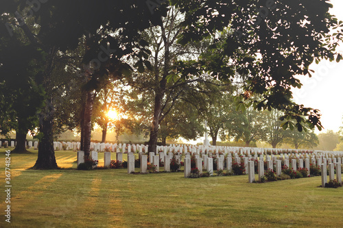 Fotografie wide view over many rows of tombstones of a war cemetary illuminated by peaceful