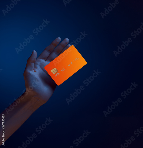 Close up female hand holds levitating template mockup bank credit card with online service isolated on blue background