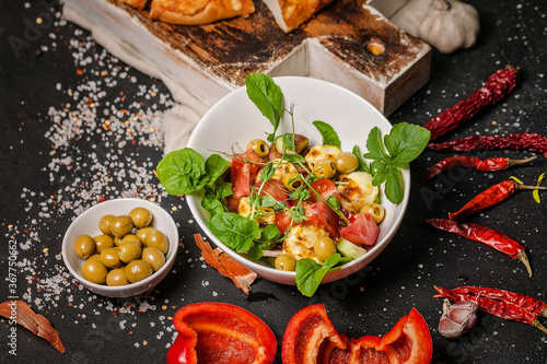 Close-up delicious salad with fried halloumi cheese, tomatoes, peppers, olives and arugula and bread with cheese. Mediterranean diet dishes