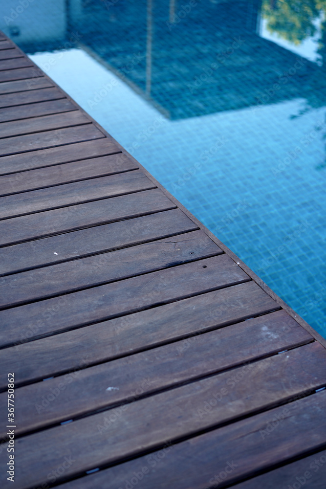 Blue swimming pool with wooden 
