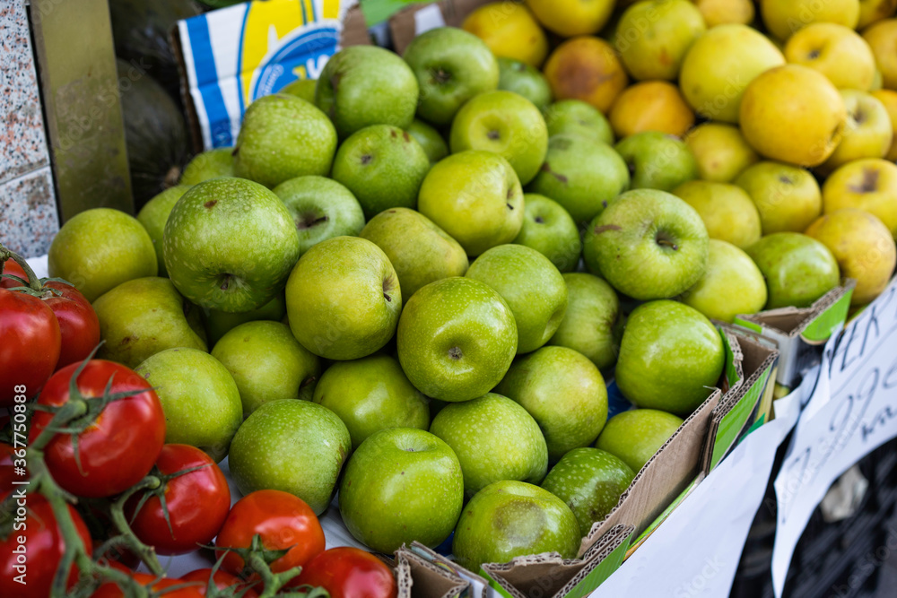Manzanas verdes expuestas al aire libre en una frutería con luz de día a la sombra Manzanas verdes expuestas al aire libre en una frutería con luz de día a la sombra