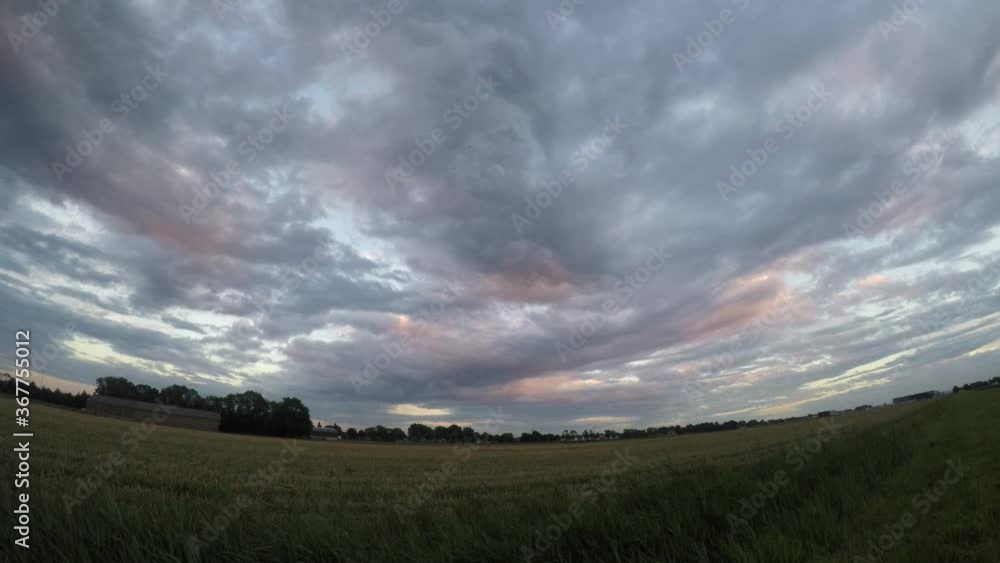 Time lapse video of midlevel clouds (altocumulus undulatus asperitas) over a farmland during sunset. Time lapse video of midlevel clouds (altocumulus undulatus asperitas) over a farmland during sunset.