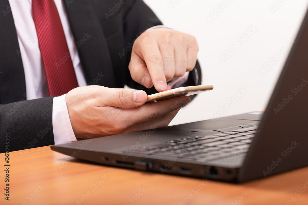 Businessman use smartphone at office and working Laptop modern. Business concept or shopping online, payment online. Businessman use smartphone at office and working Laptop modern. Business concept or shopping online, payment online.