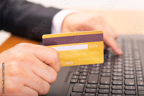 Hands holding credit card, typing on the keyboard of laptop. Online shopping concept.