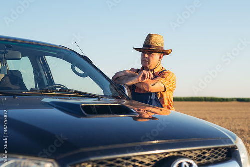 Trendy farmer standing proudly in front of his truck. © zorandim75
