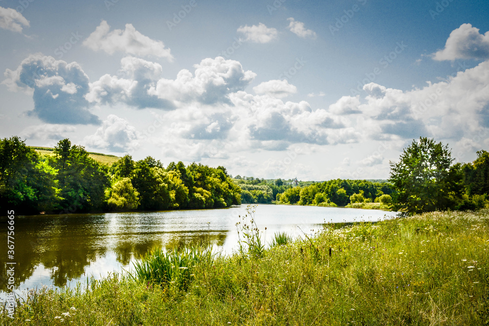 Fototapeta premium Beautiful summer landscape of green nature. Forest, river and hills
