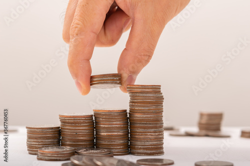 Hand putting coins on stack on table,Saving money concept or Business Growth concept photo