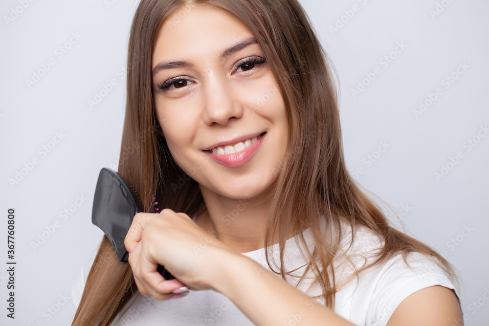 A young girl with beautiful long hair uses a com A young girl with beautiful long hair uses a com