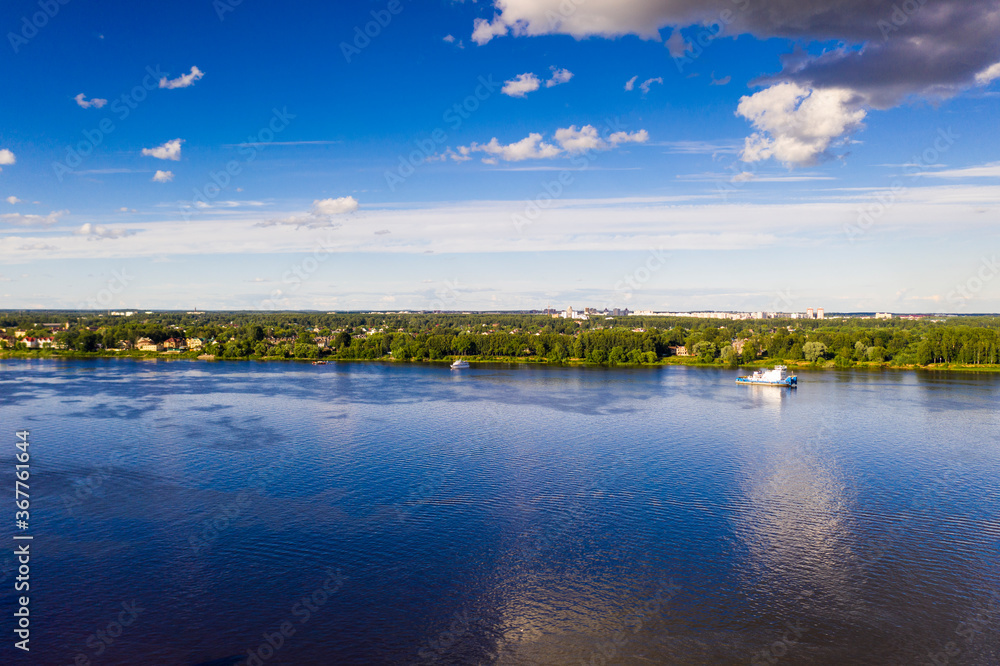 a panoramic view of the big blue river and the ships sailing along it filmed from a drone