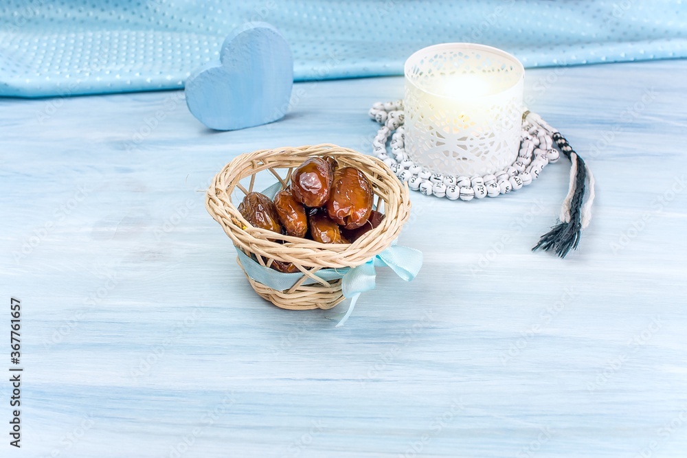 Fototapeta premium The Muslim feast of the holy month of Ramadan . Beautiful background with a shining lantern and dried dates on wooden boards.