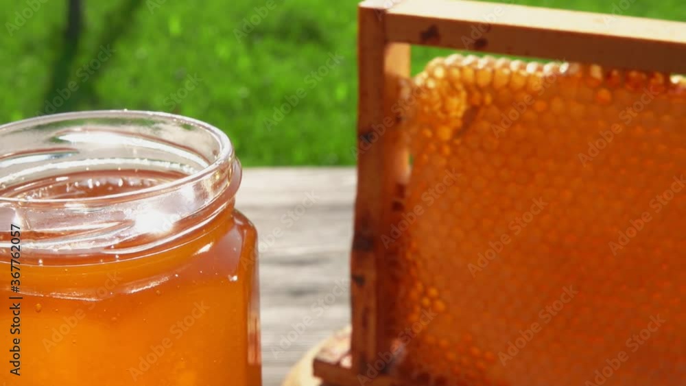 Cherry is dipped into fresh delicious honey in a glass jar on a sunny summer day Cherry is dipped into fresh delicious honey in a glass jar on a sunny summer day