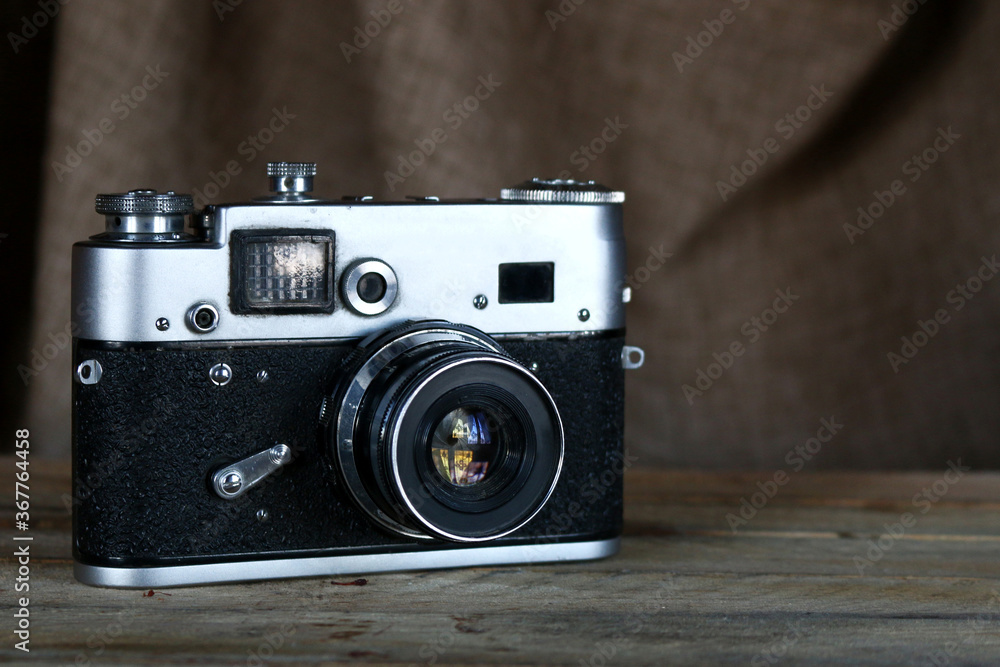 Old film camera. Vintage film photo camera on old wooden background.