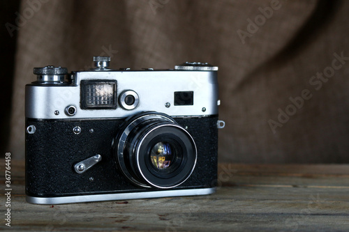 Old film camera. Vintage film photo camera on old wooden background.