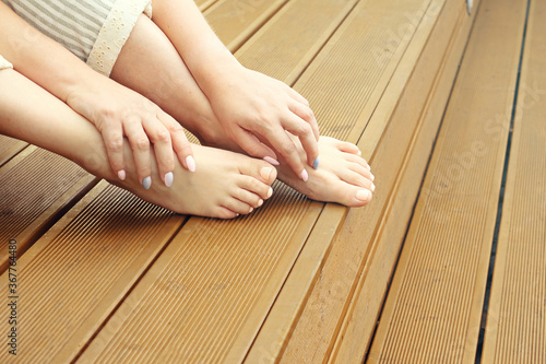 Bare feet. A woman is standing barefoot on the wooden floor.