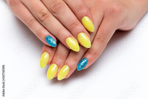 Yellow-blue manicure on sharp long nails on a white background close-up. Patriotic manicure. Ukraine.