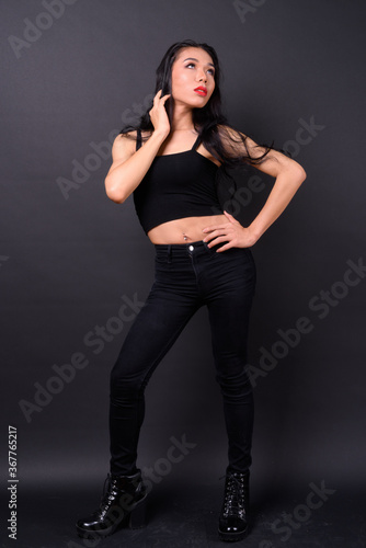 Young beautiful Asian transgender woman against black background