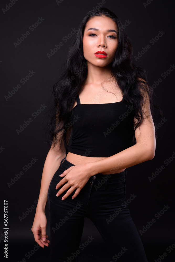 Young beautiful Asian transgender woman against black background Young beautiful Asian transgender woman against black background