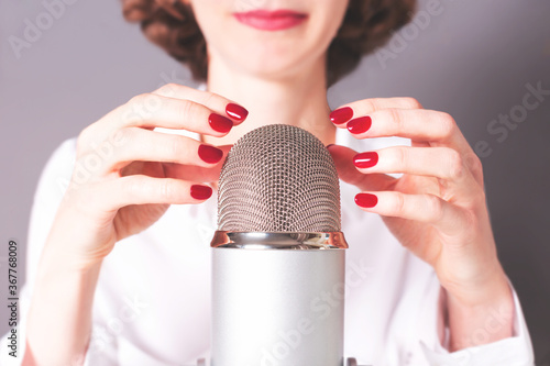 Unrecognisable girl is about to do ASMR microphone scratching and nail tapping. Trigger sounds for stress and anxiety attack relief, good sleep. photo