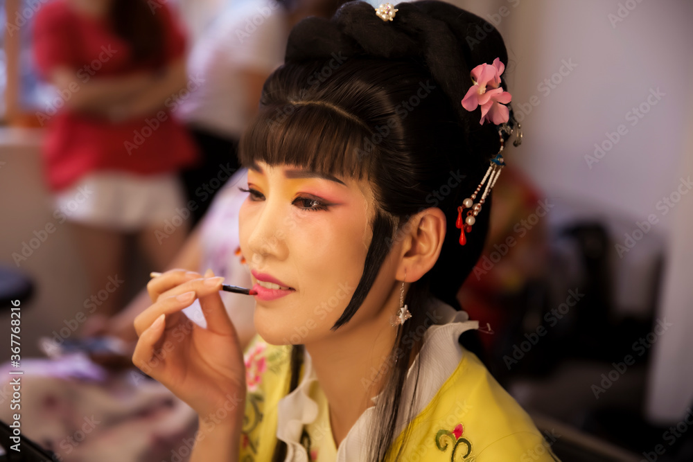 Asian Peking Opera and opera male actors disguised as women are putting