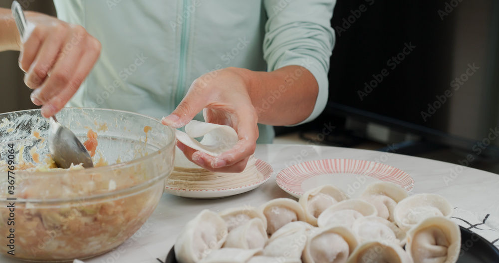 Woman making meat dumpling at home