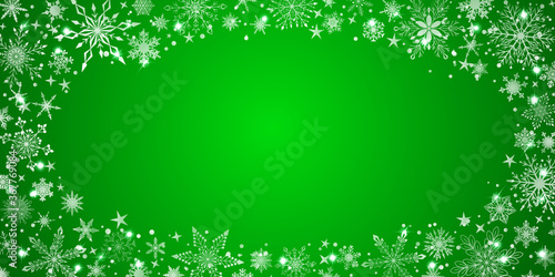 Christmas background with various complex big and small snowflakes, white on green, arranged in a ellipse