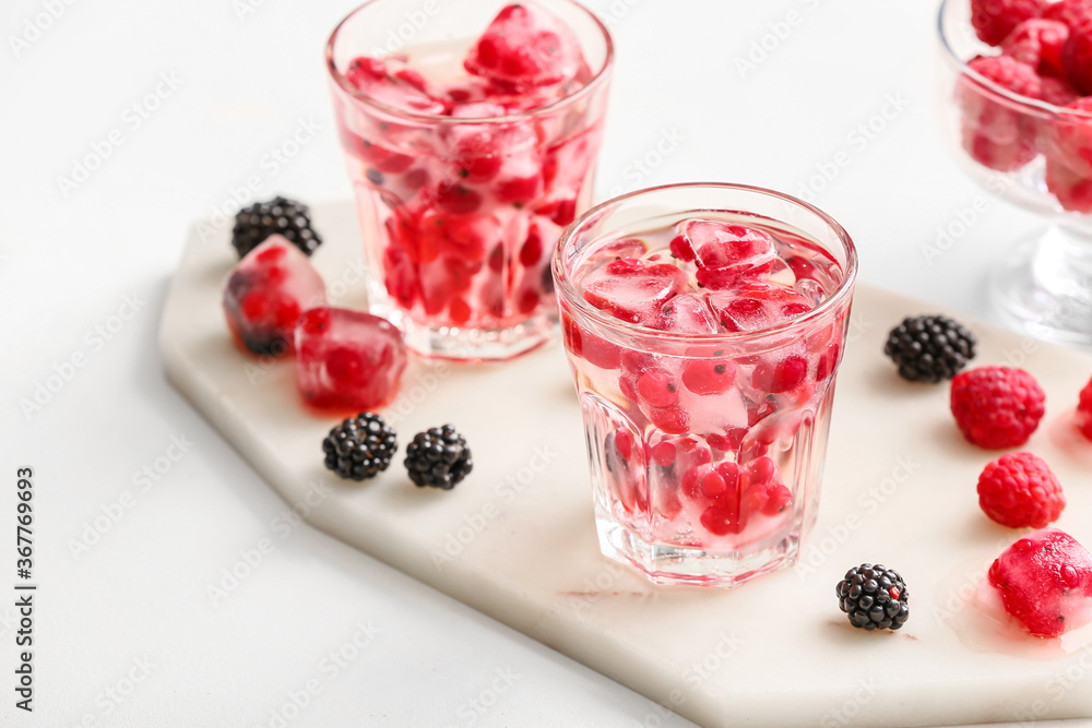 Glasses with ice and frozen berries on white background Glasses with ice and frozen berries on white background