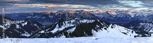 Photo Amazing sunset alpenglow panorama view to snow covered mountain ranges and dramatic sky in cold winter