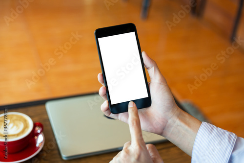 mockup woman hand using smartphone In coffee shop,Screen blank with clipping path