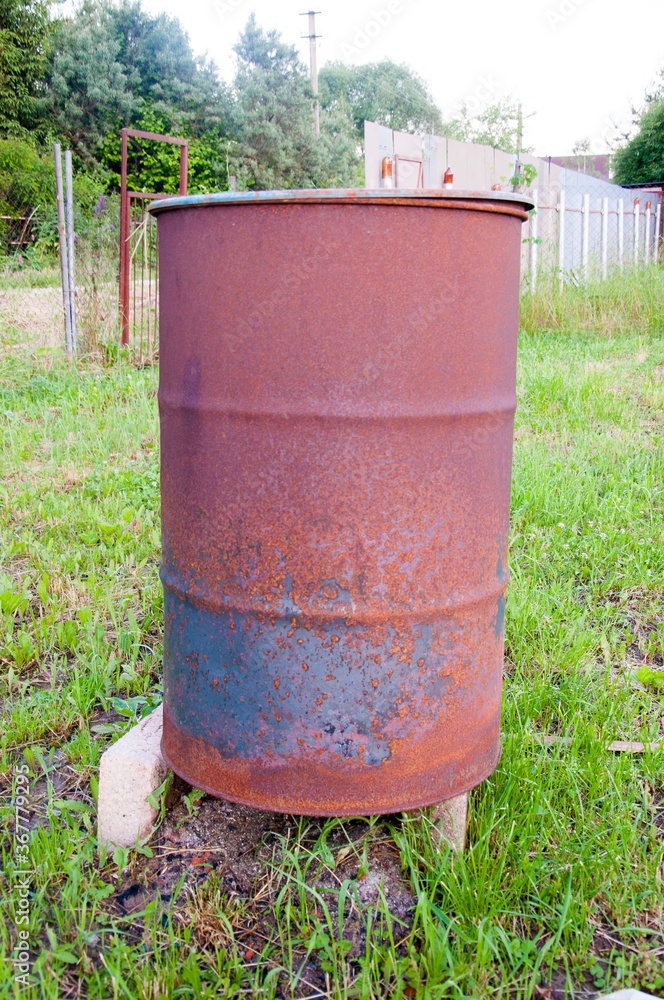 Old metal rusty barrel oil in the garden, with clipping path. Old metal rusty barrel oil in the garden, with clipping path.