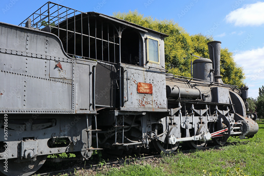 Naklejka premium Old locomotive next to the railway station