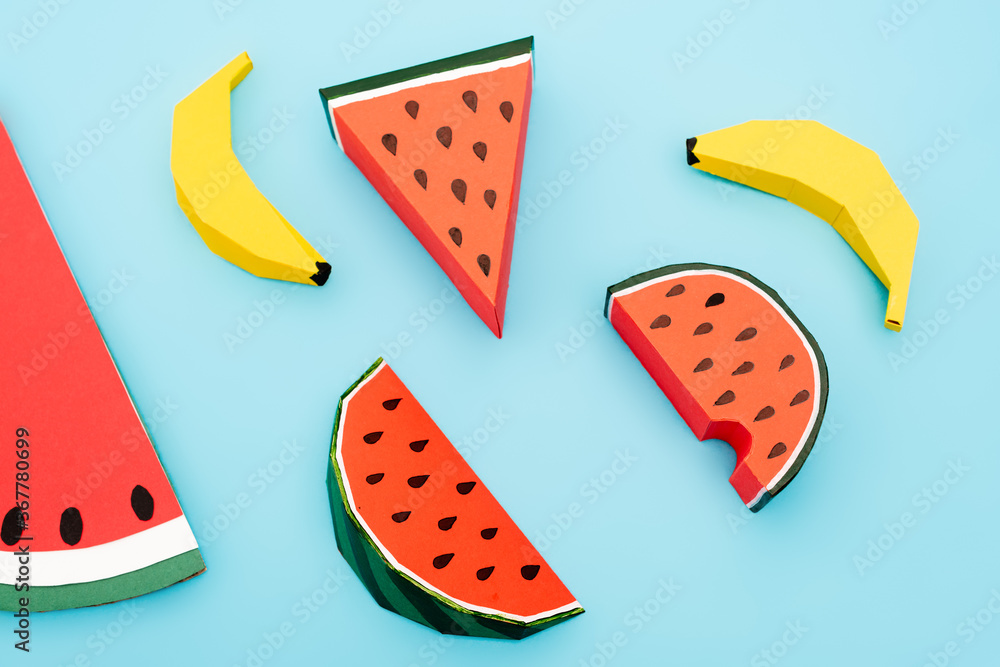 top view of paper watermelon and bananas on blue background top view of paper watermelon and bananas on blue background