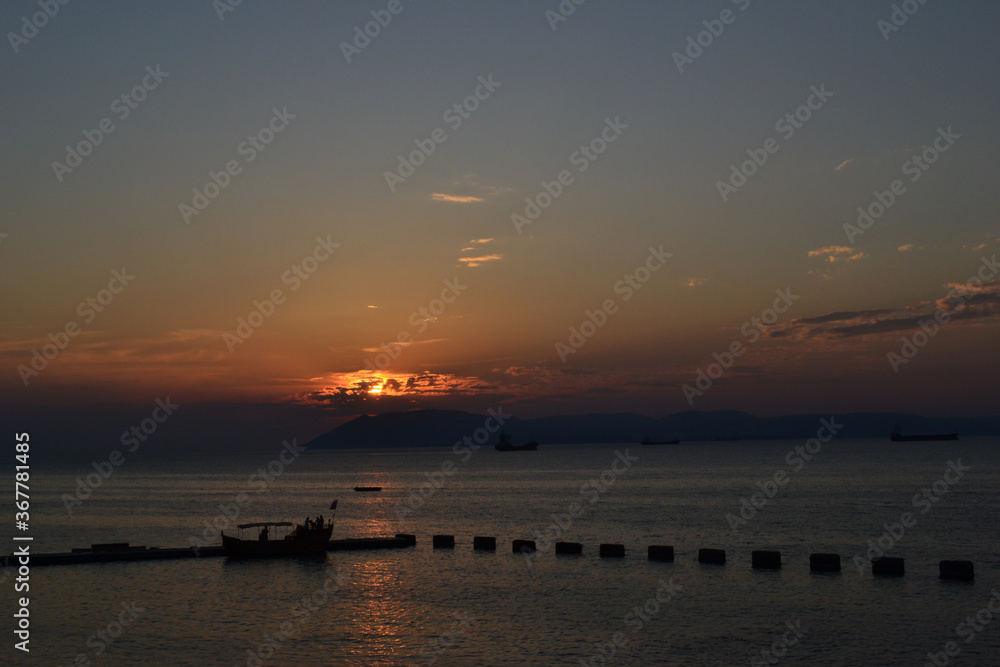 Red clouds at sunset overlooking mountains and sea Red clouds at sunset overlooking mountains and sea