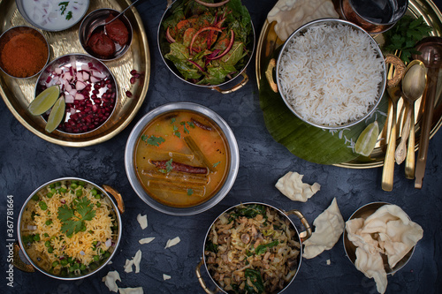 South Indian vegetarian food served on traditional platters  and trays, black background photo