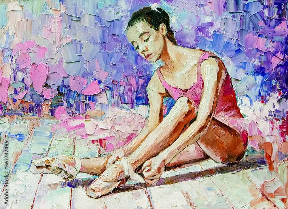 Young beautiful ballerina in a pink ballet tutu ties pointe shoes on ...