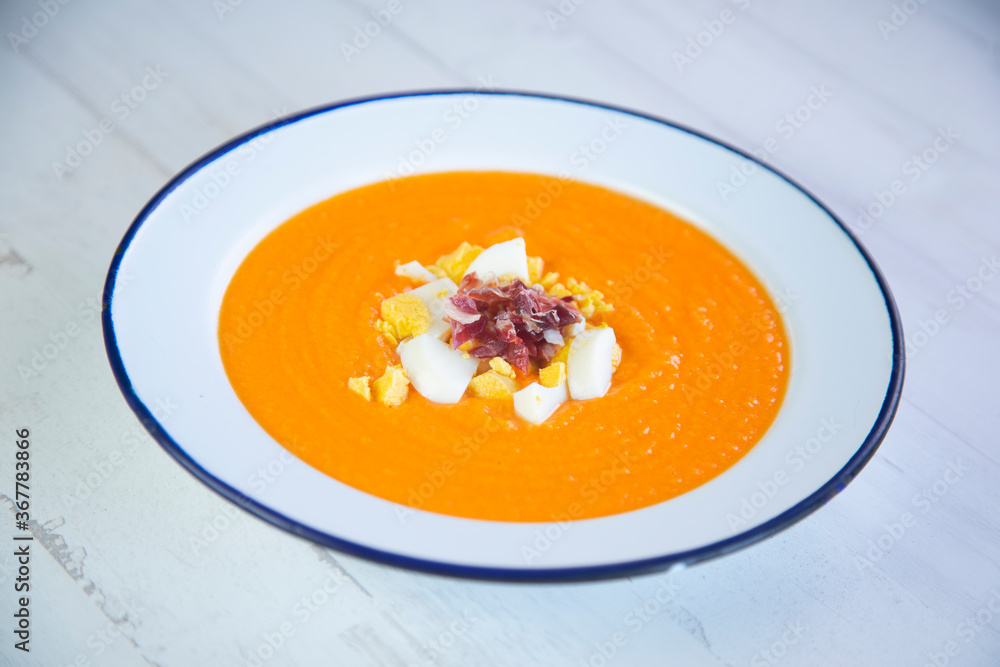Traditional spanish Salmorejo. Cold tomato soup made with garlic, tomatoes, onion, bread and served with olive oil, iberico ham and boiled egg. Traditional spanish Salmorejo. Cold tomato soup made with garlic, tomatoes, onion, bread and served with olive oil, iberico ham and boiled egg.